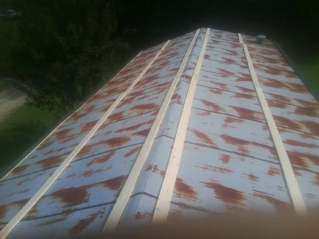 Rusted metal roof panels with new wood purlins before replacement — Storm Damage Roof Repair in East Spencer by Roofing Brothers