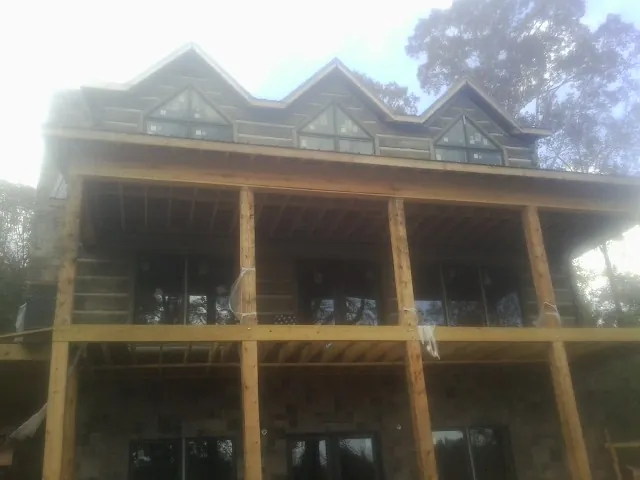 Dormers and porch framing on a large log home under construction — Roof Coating work by our crew in East Spencer