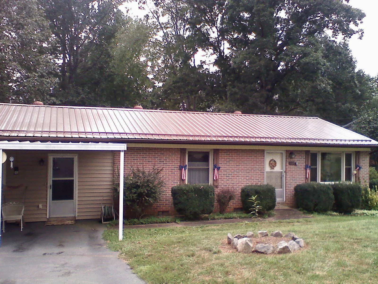 Bronze metal roof and carport on a brick ranch home — Roof Repair work by our crew in East Spencer